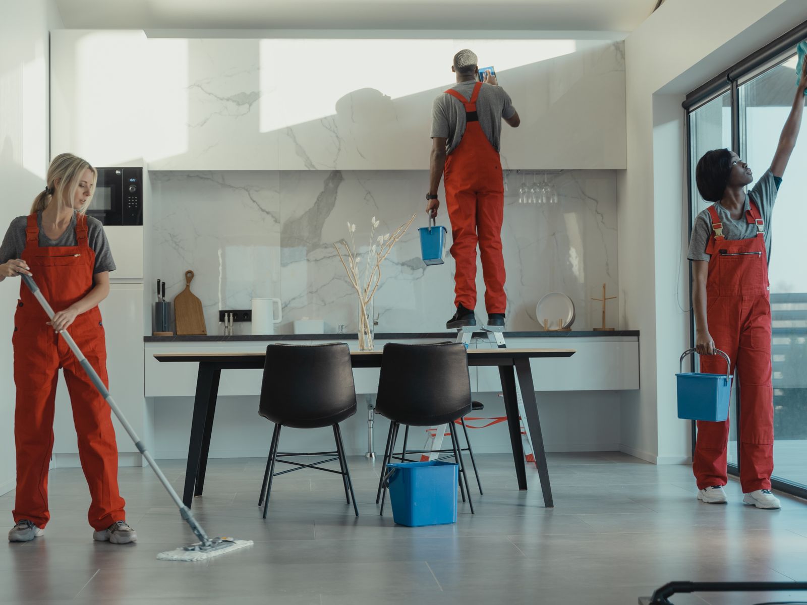 Cleaners at work across a shared dining and meeting space
